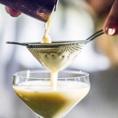 Cocktail being strained into a glass.