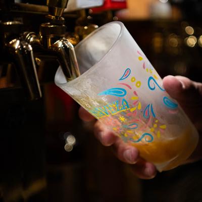 A hand holding a glass under the dispensary.