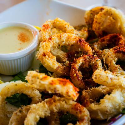 Crispy seasoned calamari served with sauce.
