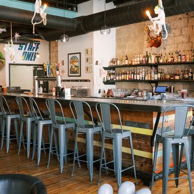 Interior, bar area, wooden top bar with metal stools, drink shelves in the back.