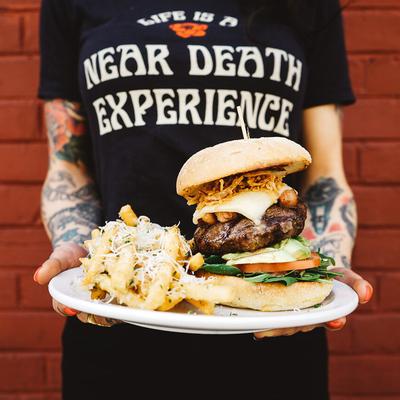 Bacon cheeseburger, with arugula, spinach, tomato, crispy shallot rings, and fries.