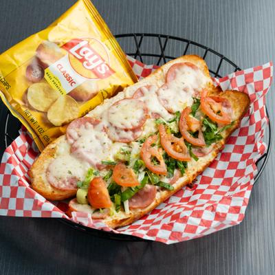 Hot Ham and Cheese sandwich served with a bag of potato chips on the side.