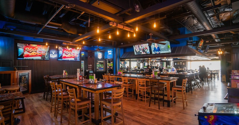 Interior, wide view, bar tables and stools, tv screens on the walls