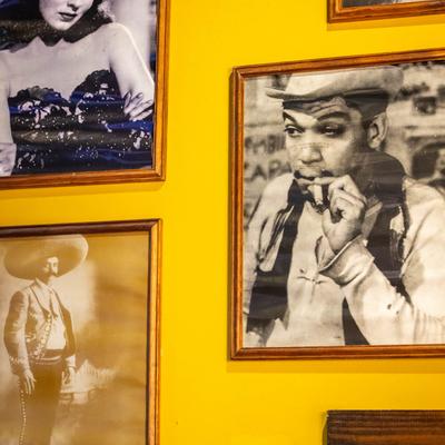 Framed black-and-white photos on a yellow wall.