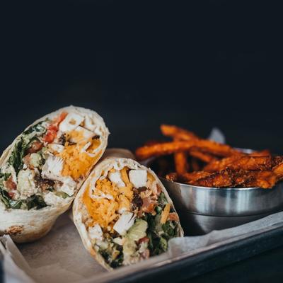 Roasted chicken wrap, with lettuce, tomatoes, avocado, and shredded cheddar.