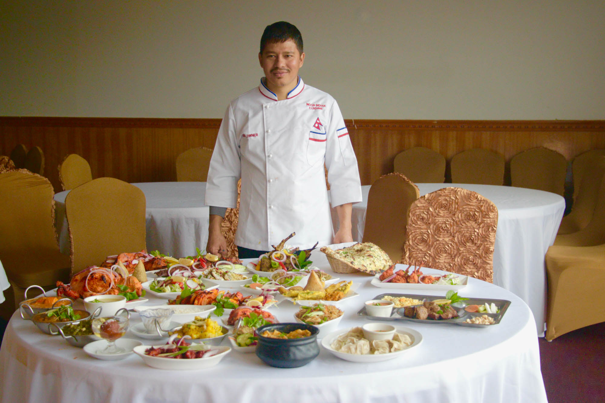 Restaurant chef displaying a table full of food