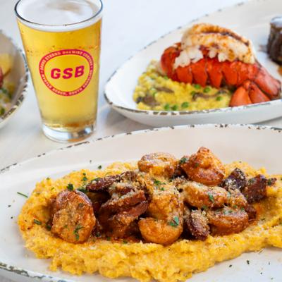Shrimp and grits, surf and turf plate, and a glass of beer.