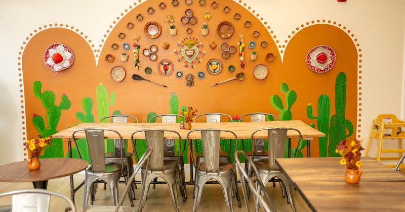 Interior - an orange cactus mural, sombreros, decorated wall, wooden tables, metal chairs