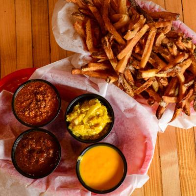 Order of Fries, red and green chili, slaw, and cheese dip, top view.