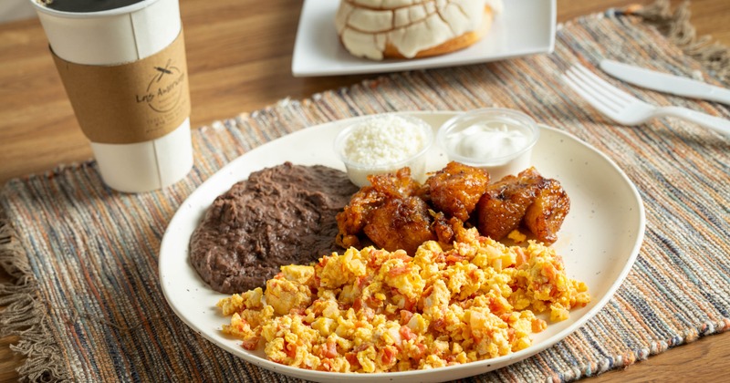 Breakfast plate with scrambled eggs, fried plantains and black beans