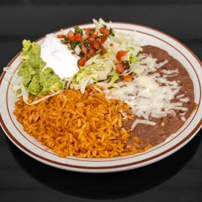 Plate of sides featuring, rice, refried beans, pico de gallo, sour creme and guacamole.