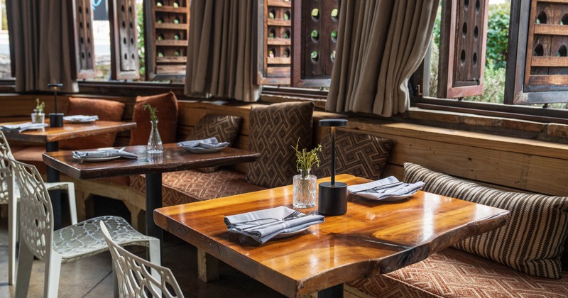 Interior, dining area, live edge wooden tables with banquette bench and chairs