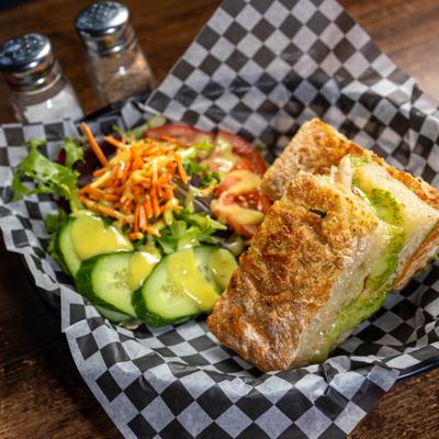 Club Grilled Cheese sandwich served with salad on the side.