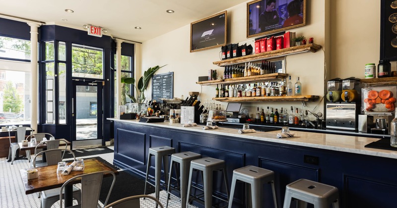 Interior, bar and seating area, marble top bar with stools, restaurant entrance and shop window