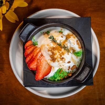 Warm pandan sticky rice with coconut ice cream, strawberries, and cookie crumbs.
