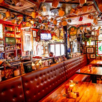 Interior, ceiling adorned with decorations, and tables lined with brown tufted benches.