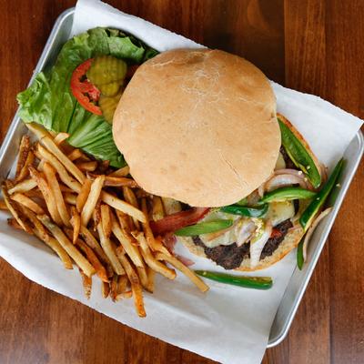 Macho Grande Burger, with applewood bacon, grilled onion, jalapenos, guacamole, pickles, and fries.