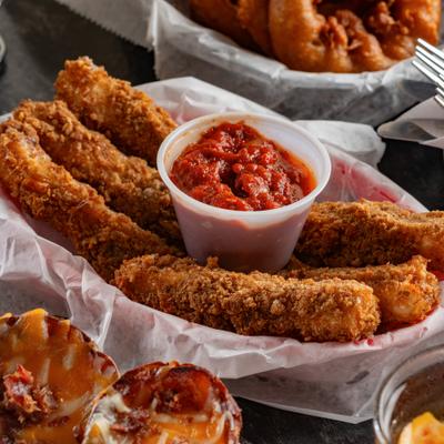 Mozzarela sticks with side of marinara sauce.