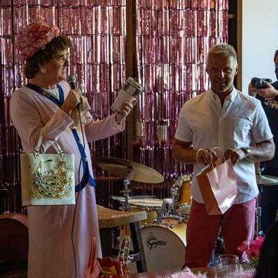 Two guys in drag drinking wine