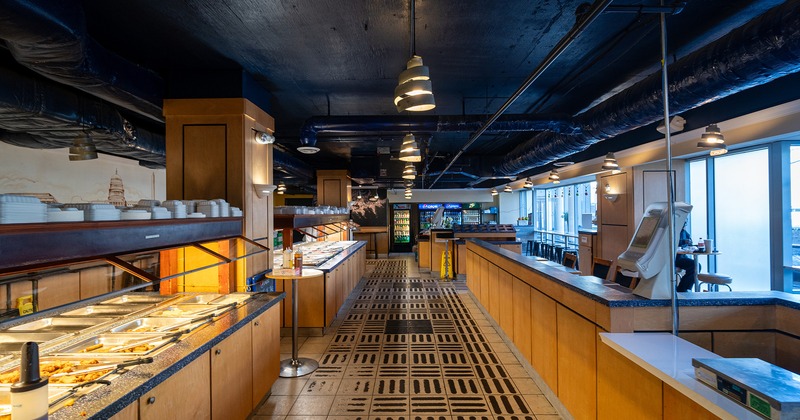 Interior,  buffet tables with various foods on one side, and a seating area on the opposite side