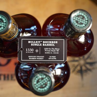 Three bottles of single barrel bourbon featuring a prominent black hangtag.