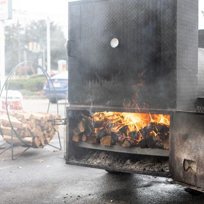 Open firebox of a large, industrial-sized barbecue smoker.