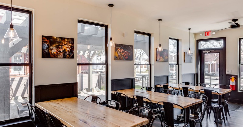 Interior, entrance, seating area, wooden top tables for six, metal chairs painted in black