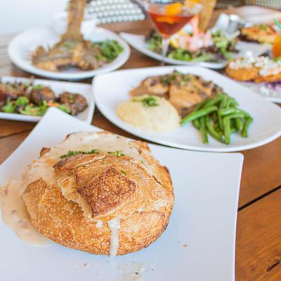 Clam chowder bread bowl plate and assorted dishes on a table.