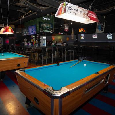 Interior featuring two pool tables with blue felt surfaces.