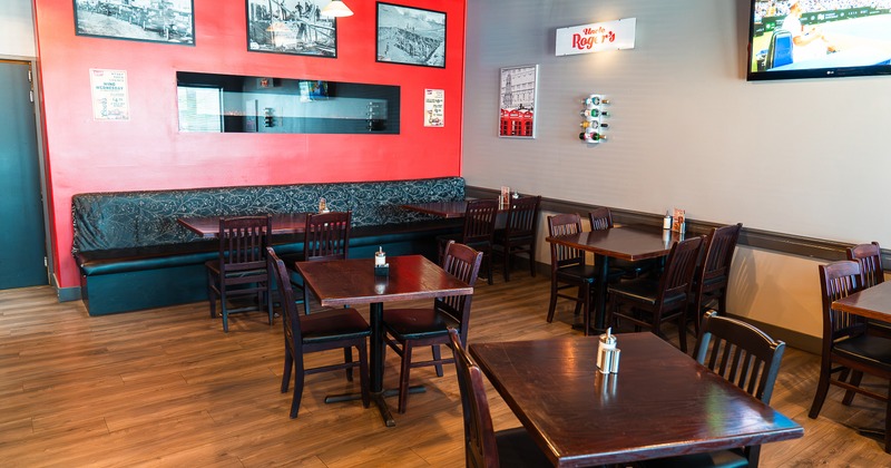 Cozy interior dining area with wooden tables and chairs and upholstered seats