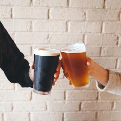 Clinking glasses of dark and light beer