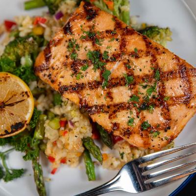 North Atlantic Salmon with mango citrus glaze, green veggies and brown rice, top view.