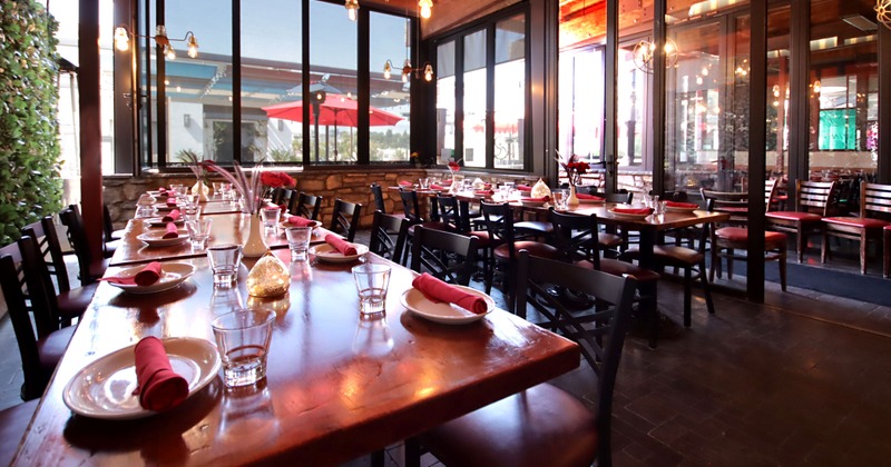 Interior, dining area, long table setups for fourteen and ten, large sliding glass door