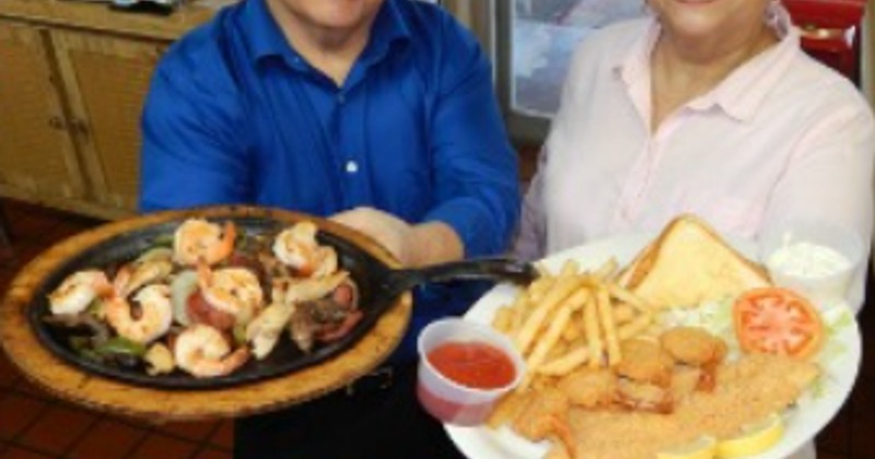 Two employees present food on plates