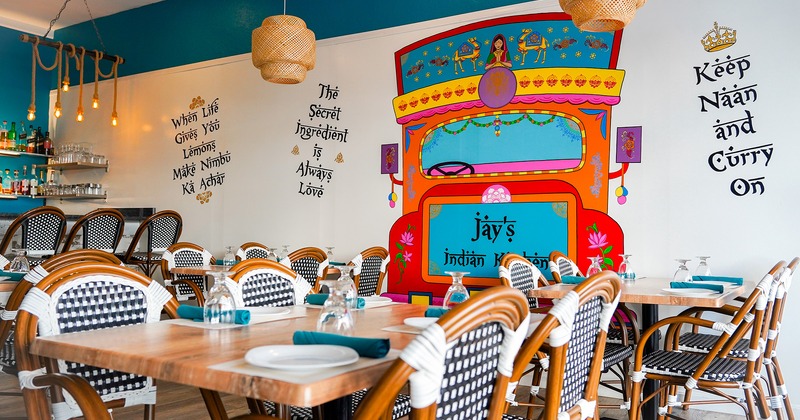 Dining room with set tables, Indian bus drawing on the wall