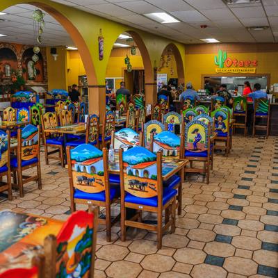 Colorful interior with vibrant hand-painted chairs and tables depicting rural scenes.