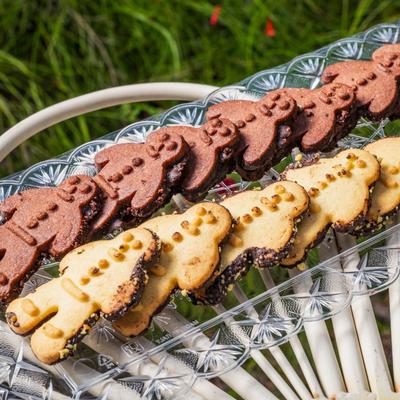 Chocolate and vanilla gingerbread man cookies on a glass tray.