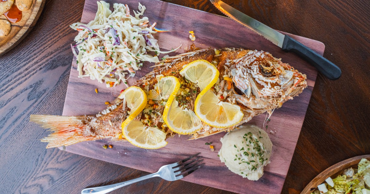Fried red snapper, served with mashed potatoes, and coleslaw