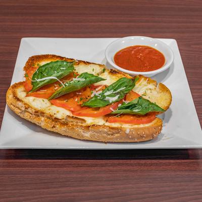 Garlic bread sandwich, with tomato, cheese, basil, and tomato sauce.