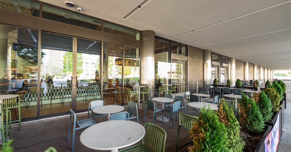 Outdoor café setting with round white tables and colorful chairs