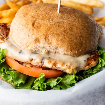 Chicken Sandwich with cheese, lettuce, and tomato, served with fries.