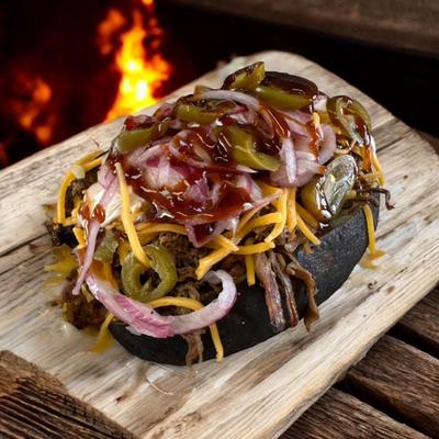 Smoked loaded potato with pulled pork, cheese, red onion, jalapenos, and BBQ sauce.
