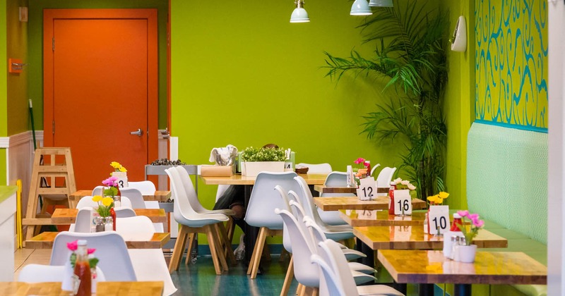 Interior, lined up tables with decorative flower pots and seats