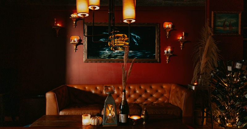 Lounge seating with decorations and candle light on a coffee table, painting on the wall and lights