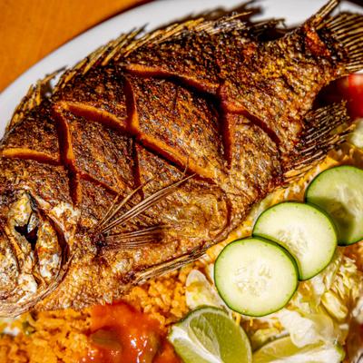 Fried whole fish with rice and salad.
