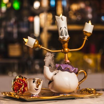 A whimsical tea set with Beauty and the Beast characters.