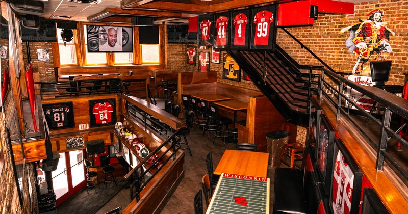 Interior, upstairs seating area, wooden tables with chairs, framed jerseys decoration