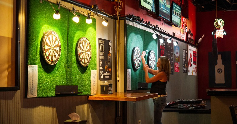 Interior, dart boards, posters, and TVs on a wall