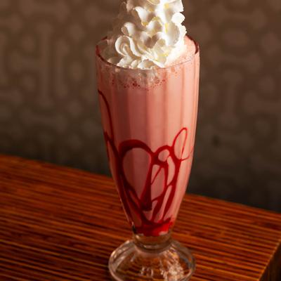 Strawberry milkshake topped with whipped cream.