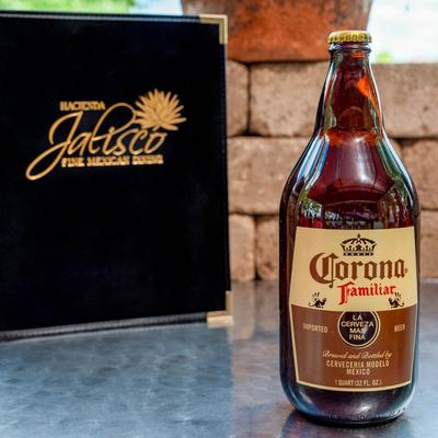 A menu and a bottle of Mexican beer on a table.